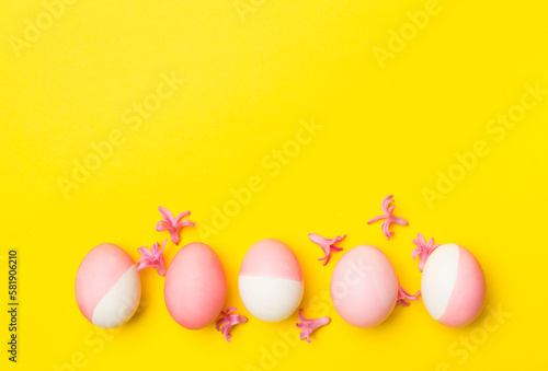 Pink Easter eggs with decor on color background, top view
