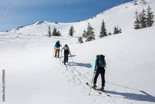 The winter mountains provide a challenging but rewarding climb for this group of skiers, who forge ahead with teamwork