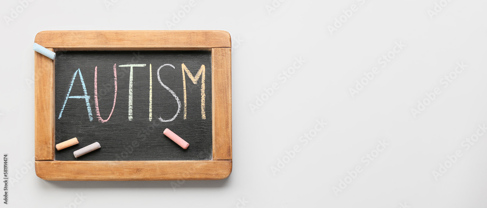 Chalkboard with word AUTISM on light background with space for text