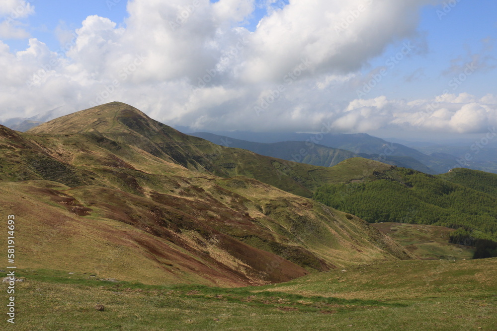 Fabulous landscapes of Corne alle Scalle in the Bolognese Apennines of Italy in the middle of the month of May, green mountain peaks against the backdrop of white clouds. Fabulous landscapes of Corne alle Scalle in the Bolognese Apennines of Italy in the middle of the month of May, green mountain peaks against the backdrop of white clouds.