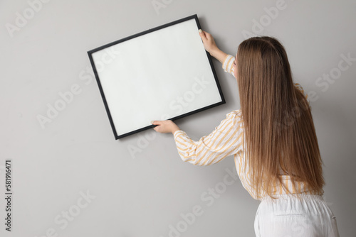 Young woman hanging blank f...
