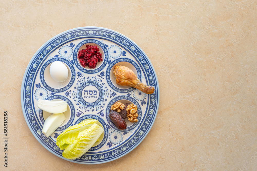 Traditional Seder Plate for Jewish holiday Pesach on marble background with copy space. Hebrew word on plate means 