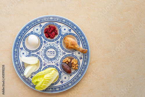 Traditional Seder Plate for Jewish holiday Pesach on marble background with copy space. Hebrew word on plate means "Passover".