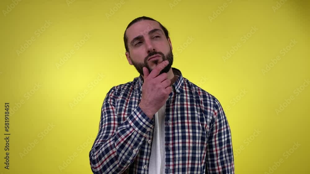 Portrait adult bearded man in casual clothing thinks worried about question, concerned, holding hand on chin isolated on yellow background. Puzzled middle-aged male seeking solution, resolve problem Portrait adult bearded man in casual clothing thinks worried about question, concerned, holding hand on chin isolated on yellow background. Puzzled middle-aged male seeking solution, resolve problem