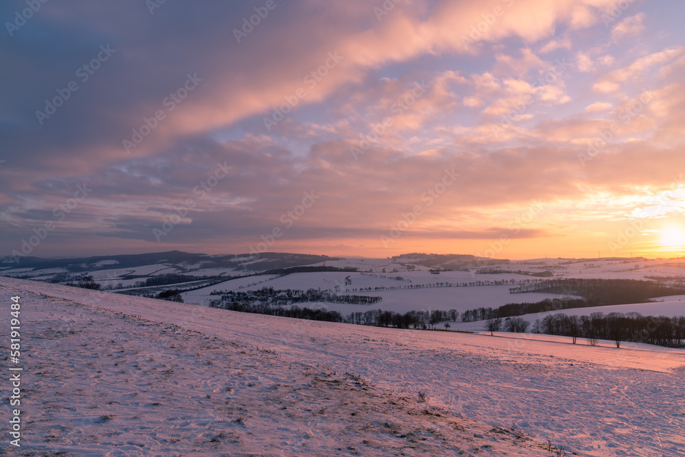 Winter panorama, landscape fields, meadows, trees. Winter morning of a new day. Orange purple sunset landscape. Panoramic view.