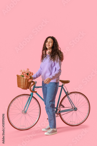 Teenage girl with bicycle and flowers on pink background © Pixel-Shot