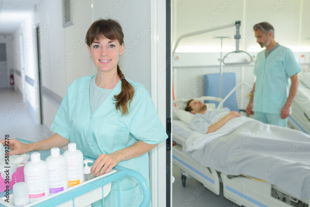 happy female nurse pushing trolley in hospital hallway happy female nurse pushing trolley in hospital hallway