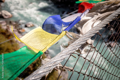 Prayer flags on Hillary bridge: legendary suspension bridge connecting two sides of the valley on the way from Phakding to Namche bazar	 photo