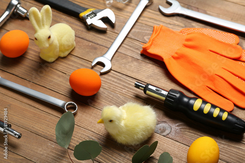 Photography Construction tools with Easter eggs, rabbit and chicken on wooden background, cl