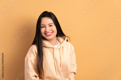 joyful brazilian woman smiling and looking at camera in studio shot. checking smartphone   © Vergani Fotografia