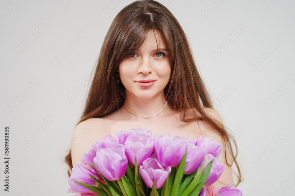 portrait of a woman topless with a bouquet of tulips on a white background. portrait of a woman topless with a bouquet of tulips on a white background.