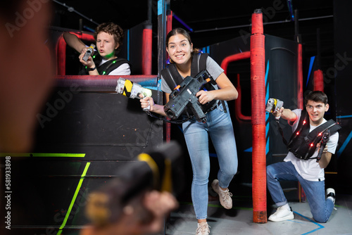 Three people playing lasertag in arena
