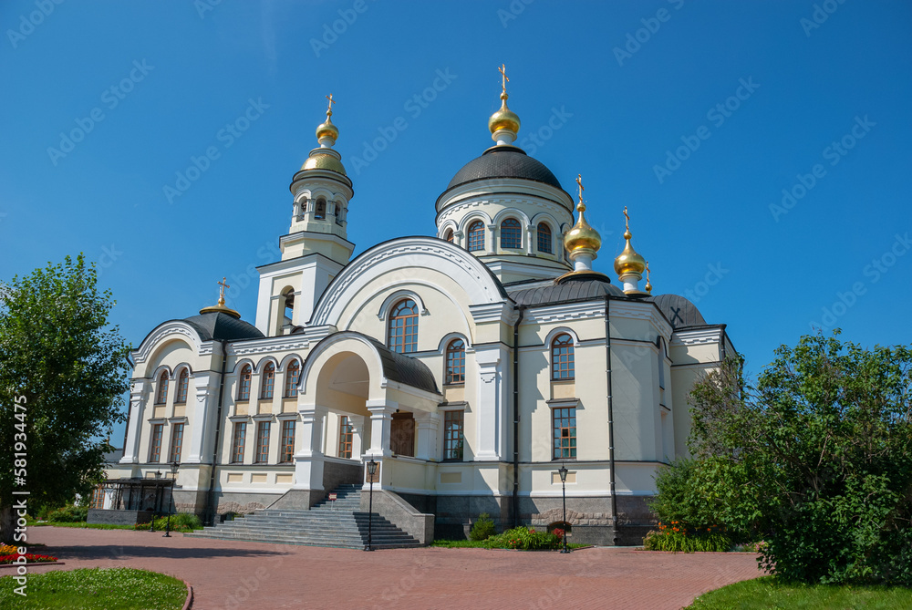 Three domes with crosses (one golden and two green) of the Orthodox Church, blue sky.