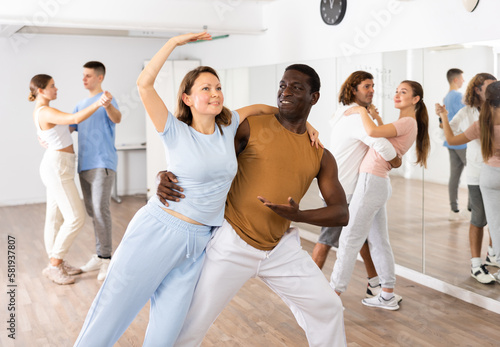 Adult male and adult female dancing pair dance in dance hall