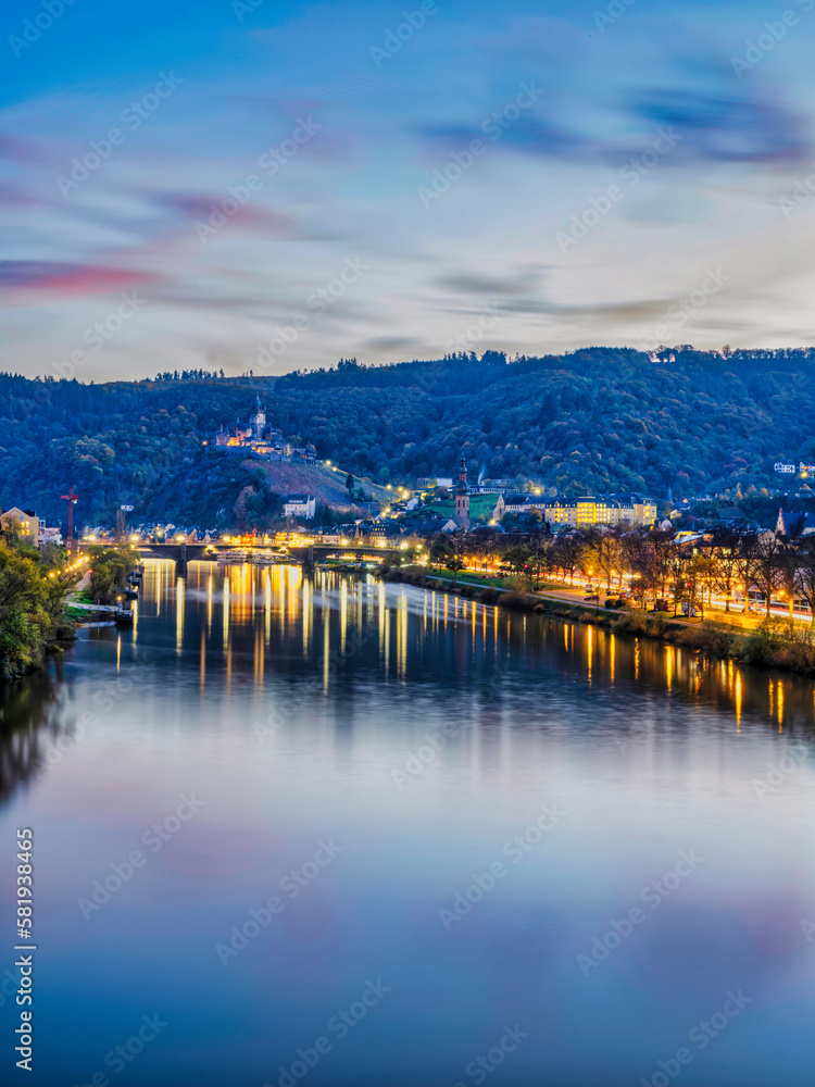 Long exposure shot of Cochem town and castle at dusk with colourful lights reflecting on Moselle river during autumn season in Cochem-Zell district, Germany