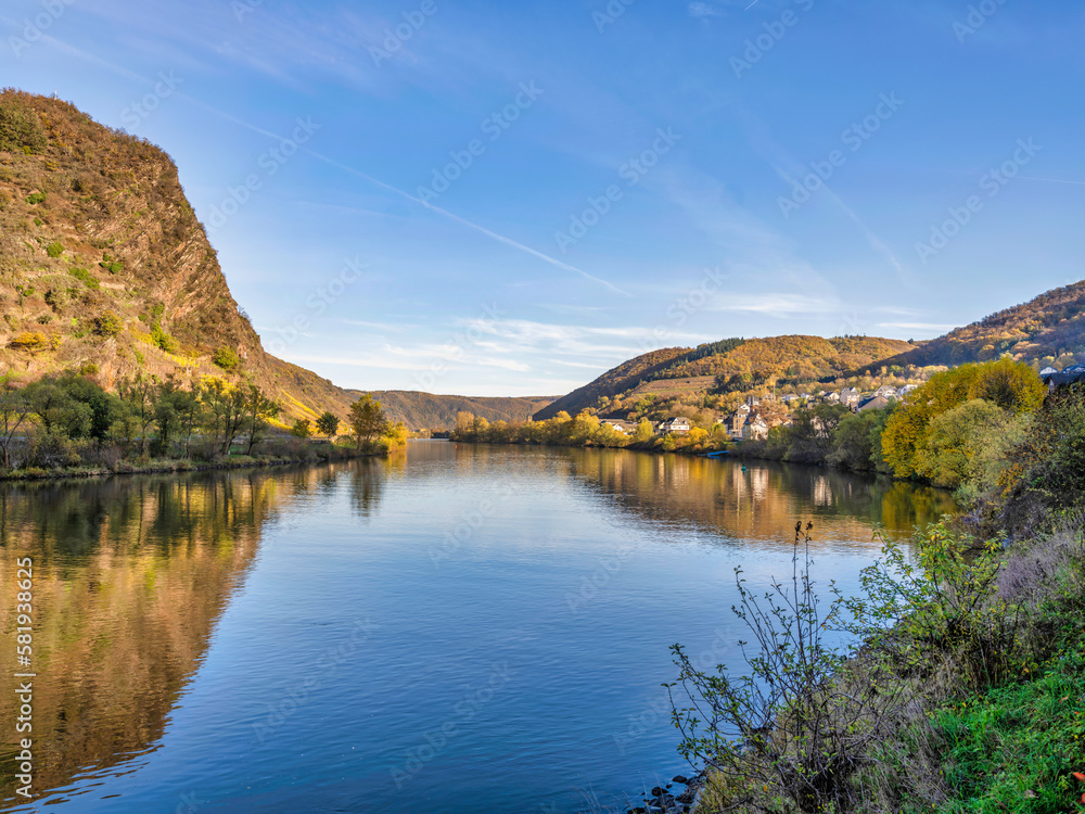 Moselle river and Zehl village in the afternoon during colourful autumn season in Cochem-Zell district, Germany Moselle river and Zehl village in the afternoon during colourful autumn season in Cochem-Zell district, Germany