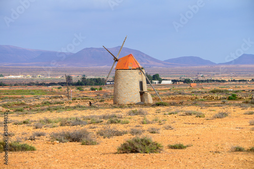 Old traditional Canarian grain wind mill near Antigua village, countryside landscape of Fuerteventura island, Spain