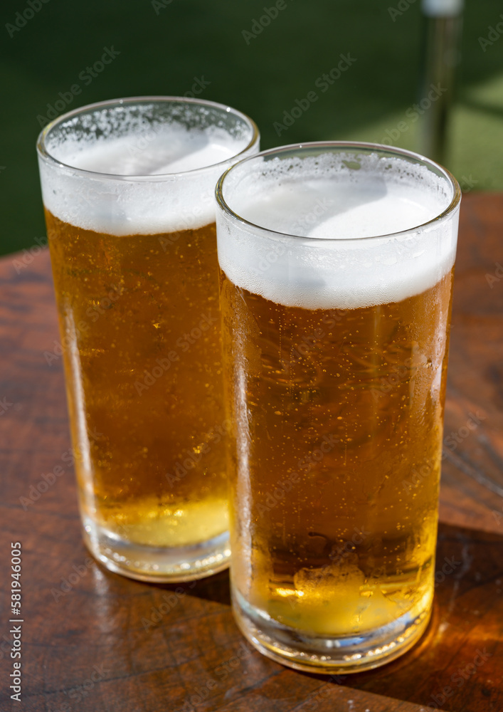 Fresh draught lager or IPA beer is glass served in outdoor cafe close up, pint of beer close up Fresh draught lager or IPA beer is glass served in outdoor cafe close up, pint of beer close up