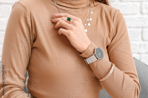 Woman with stylish wristwatch sitting at home, closeup