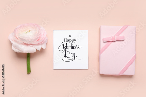 Greeting card with text HAPPY MOTHER'S DAY, gift and beautiful ranunculus flower on pink background © Pixel-Shot