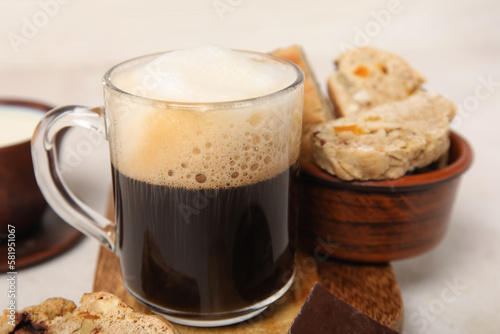 Delicious biscotti cookies and glass of coffee on white grunge background
