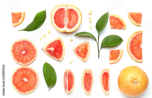 Composition with pieces of ripe grapefruit  seeds and plant leaves on white background