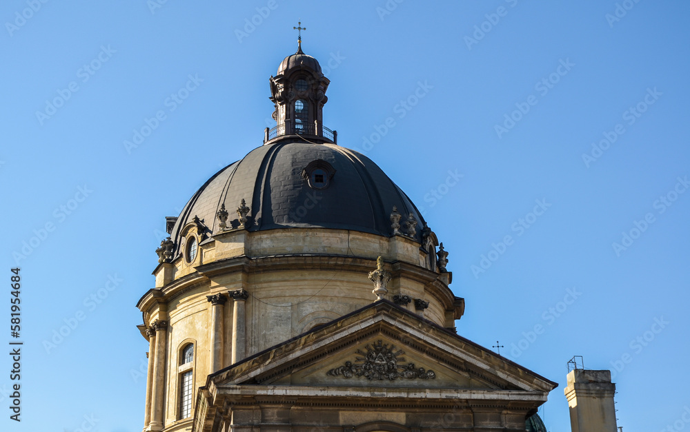 View to the dome with a cross of the Dominican Cathedral on blue sky background in sunny day in Lviv, Ukraine