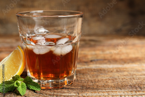 Glass of rum on wooden background, closeup