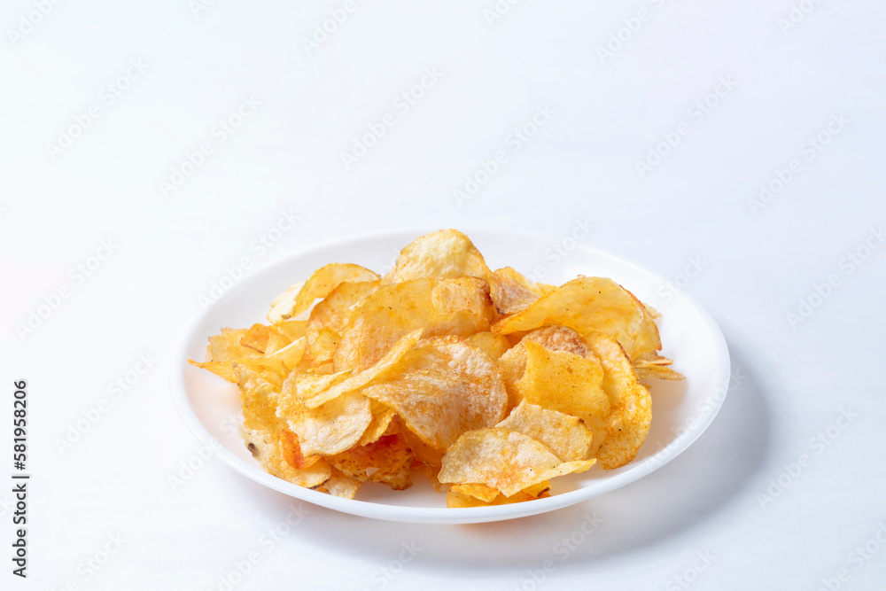 Potato chips on a white plate isolated on a white background. Potato chips on a white plate isolated on a white background.