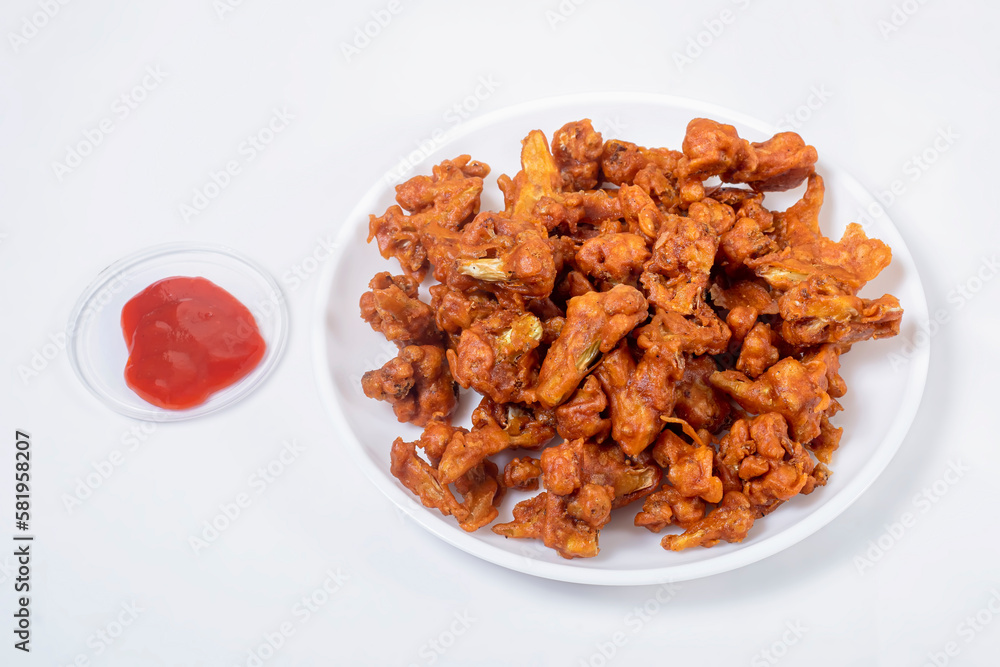 Crispy Fried Gobi Manchurian on white plate with ketchup on white background. Crispy Fried Gobi Manchurian on white plate with ketchup on white background.