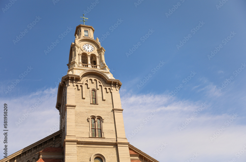 historical church landmark with ancient architectural tower with european style medieval design downtown area symbolizing religion and christianity 