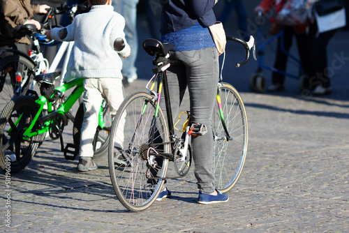 Woman stands with a road bike on cobblestones in the city