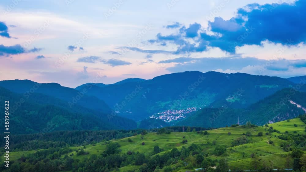 Multicolored sky with clouds and sunset light over the Rhodope Mountains with a intermountain village Multicolored sky with clouds and sunset light over the Rhodope Mountains with a intermountain village