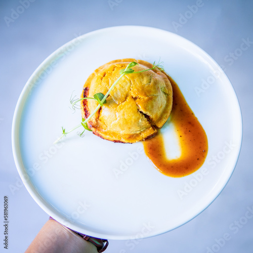 A plate of food with a red sauce on it and a small piece of food on the side.