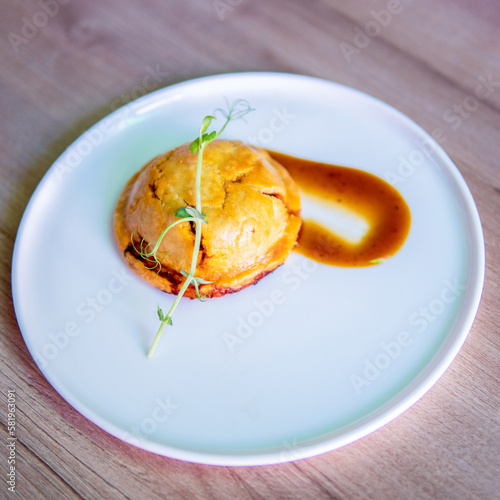 A plate of food with a red sauce on it and a small piece of food on the side.