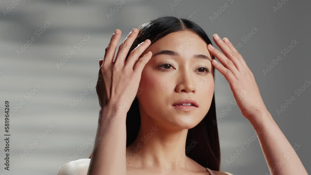 Positive model with luminous skin creating beauty ad, with cosmetics for glowing radiant appearance. Asian woman posing in studio and advertising body positivity campaign on camera. Positive model with luminous skin creating beauty ad, with cosmetics for glowing radiant appearance. Asian woman posing in studio and advertising body positivity campaign on camera.