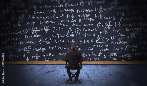 Businessman Thinking How to Solve Problem Concept with Blackboard with Math and Physics Formula and Equations. The Young Man setting on Chair 