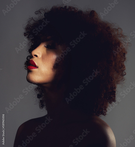 Beauty, shadow and woman with afro and makeup as skincare, cosmetic and self care in the dark or night. Spotlight, creative and face of female model with mystery aesthetic and luxury fashion