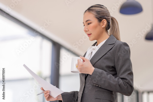 Portrait of a business Asian woman working at office reading and checking searching document tax a letter in a workplace office.