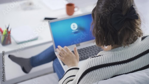 Home office worker woman enters password on her laptop.
The woman who enters the password on her laptop starts working on her opened laptop.
