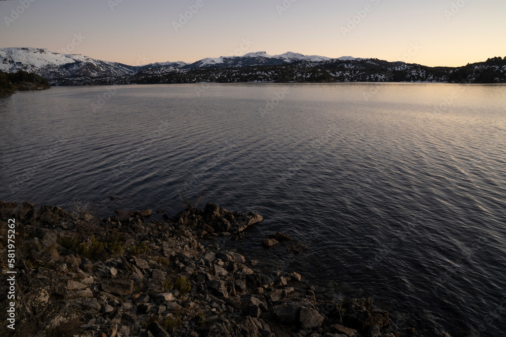 View of the lake and mountains at nightfall. Beautiful sunset colores in the water and sky.
View of the lake and mountains at nightfall. Beautiful sunset colores in the water and sky.