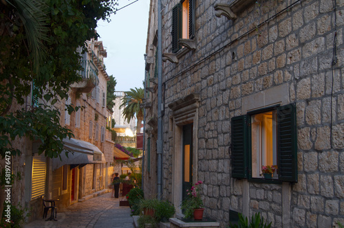 Fototapeta Naklejka Na Ścianę i Meble -  small walkway or alley with historic stone buildings in Hvar, Croatia in late afternoon