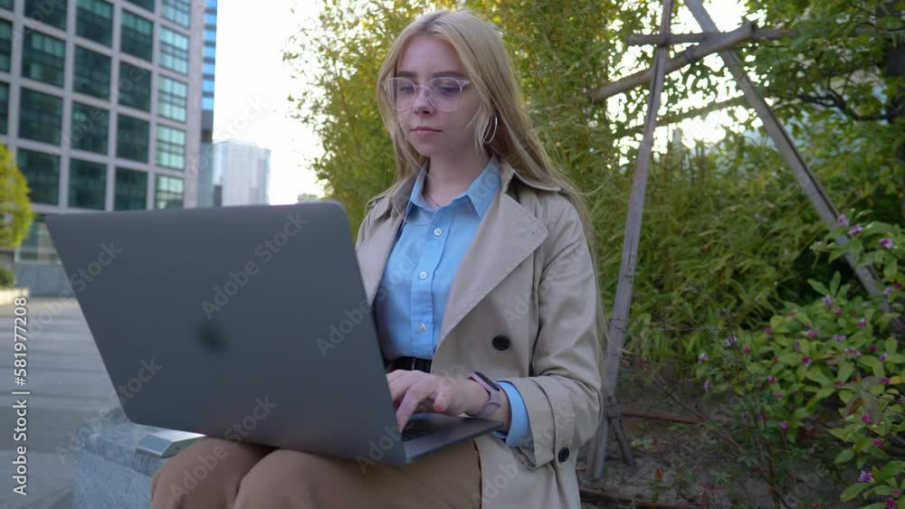 young female businesswoman working on laptop in modern city centre, professional urban lifestyle, young woman at her first job using modern technology young female businesswoman working on laptop in modern city centre, professional urban lifestyle, young woman at her first job using modern technology