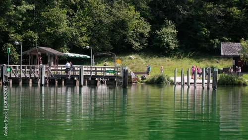 People waiting at Salet landing stage at Koenigssee Berchdesgaden Bavaria Germany. Sunny Summerday. Shot from boat view photo