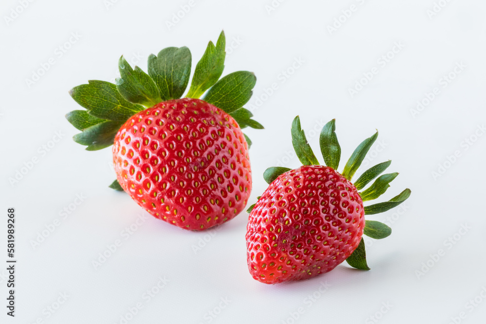 Two isolated fresh strawberries against a white background. Two isolated fresh strawberries against a white background.