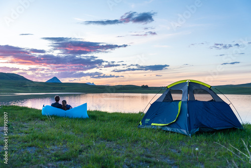Couple and Tent Near Mountain Lake