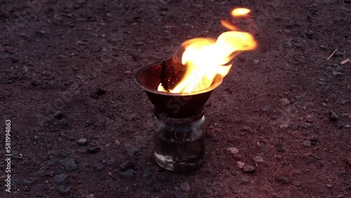 Props, inventory for the fire show. Evening show program on the street. A fire bowl with kerosene. Slow motion.