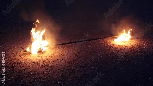 Props, inventory for the fire show. Evening show program on the street. Burning Spark staff with kerosene. Slow motion.