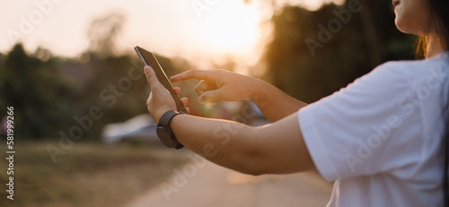 Close up woman hand hold using smart phone on outdoor park street background. Copy space of technology business and travel holiday concept. Vintage tone filter effect color style.