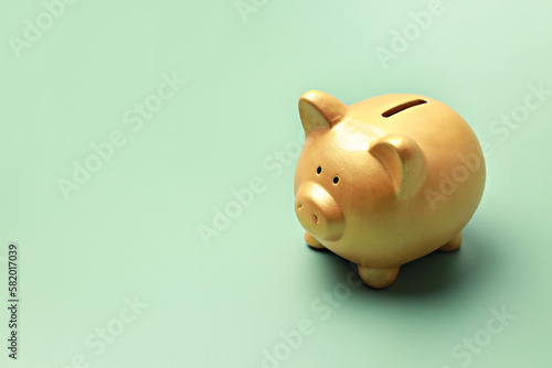 Gold piggy bank on green background